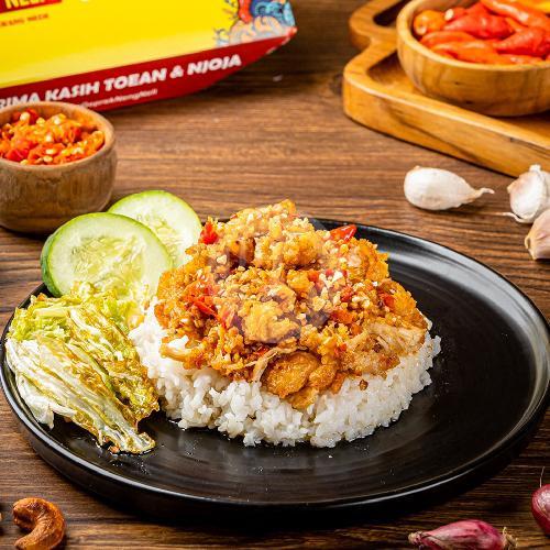Ayam geprek combo meal with crispy chicken, chili sambal, cucumber, and cabbage on the side.